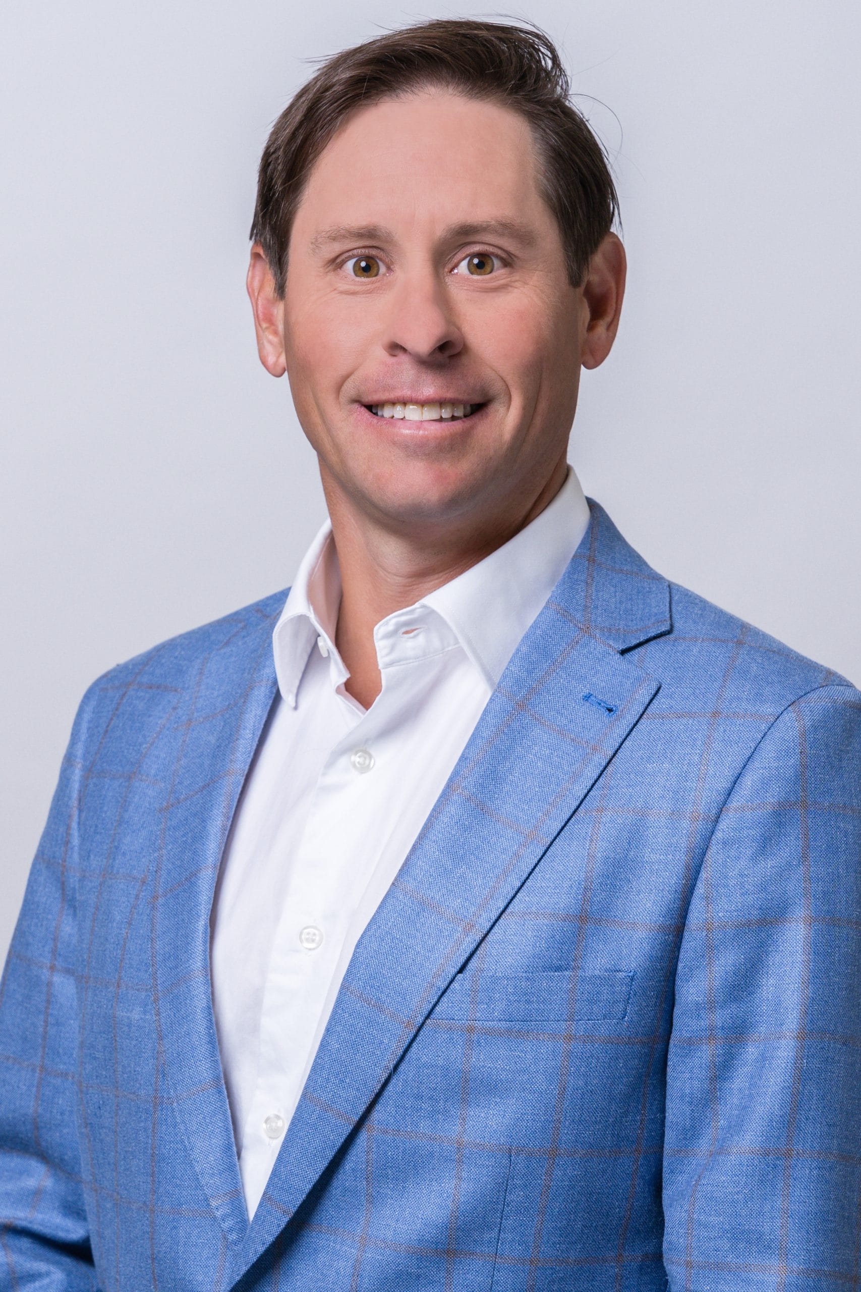 a man wearing a suit and tie smiling at the camera a man wearing a suit and tie smiling at the camera
